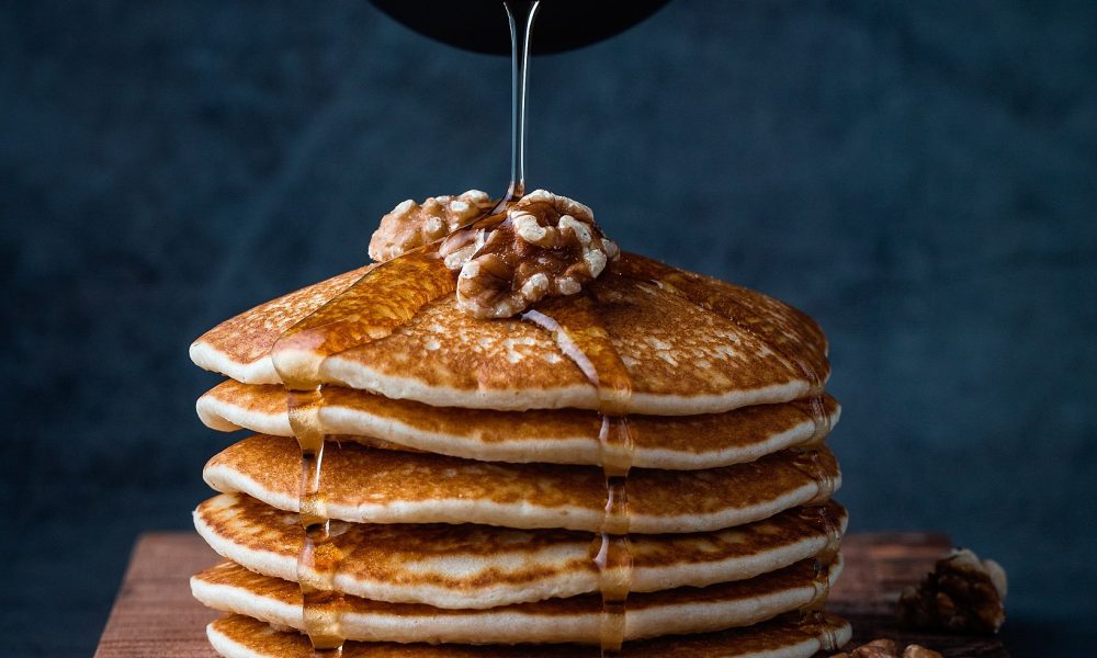 Foodiesfeed.com_pouring-honey-on-pancakes-with-walnuts